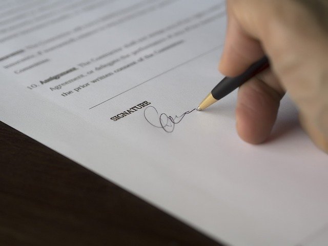 Hand signing a lease contract document