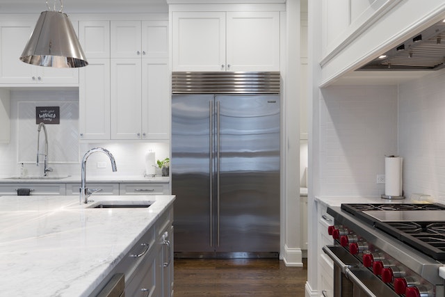 Modern-bright-lit-kitchen-with-stainless-steel-appliances-and-white-cabinets