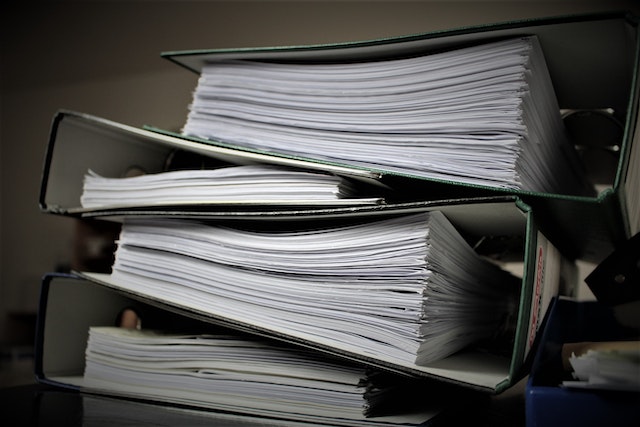 Four binders full of documents stacked on top of each other