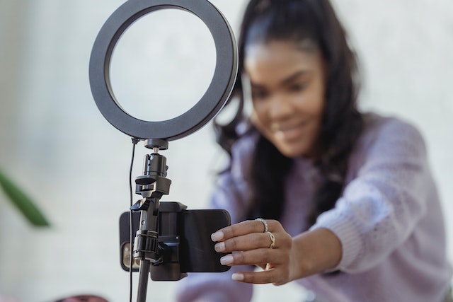 person-setting-up-a-phone-and-a-ring-light-on-a-tripod