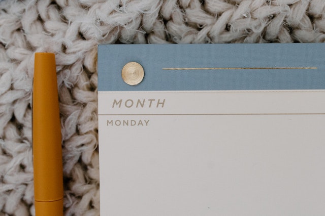 "Monday" page on a schedule, next to a pen